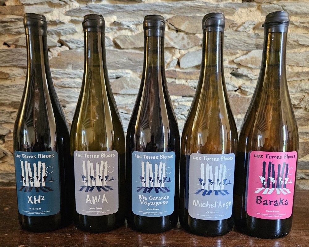 Les cinq cuvées alignées devant un mur de schiste : XH², Awa, Ma Garance Voyageuse, Michel'Ange, Baraka