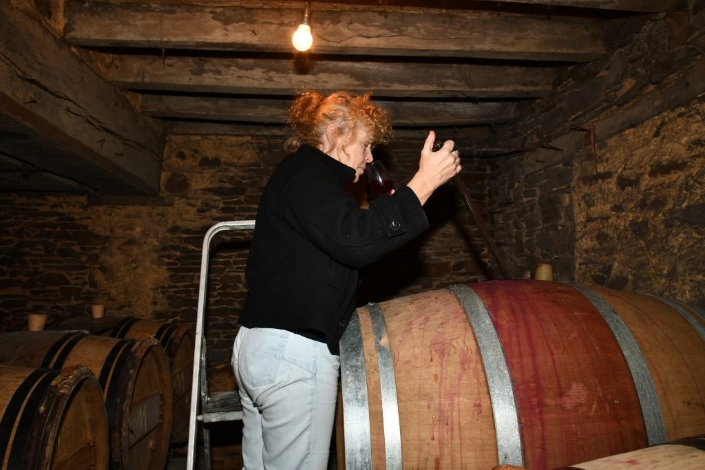 Xavière Hardy goûtant un vin à la barrique dans la cave